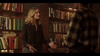 Movie still from “You” (2018), created by Sera Gamble – A woman standing next to a man in front of a book shelf; Medium shot, Over the shoulder angle