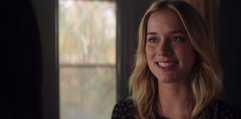 Movie still from “You” (2018), created by Sera Gamble – A beautiful young lady smiling for the camera; Close Up shot, Over the shoulder angle