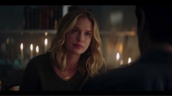 Movie still from “You” (2018), created by Sera Gamble – A beautiful young woman sitting in front of candles in a room; Close Up shot, Over the shoulder angle