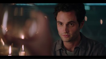 Movie still from “You” (2018), created by Sera Gamble – A person with a candle in a room; Close Up shot, Over the shoulder angle