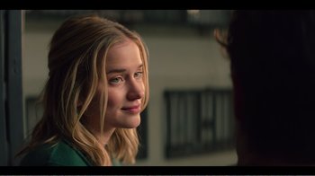 Movie still from “You” (2018), created by Sera Gamble – A young blonde woman looking at the camera; Close Up shot, Over the shoulder angle