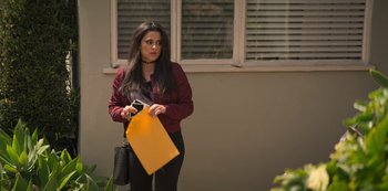 Movie still from “You” (2018), created by Sera Gamble – A woman holding a yellow shopping bag in front of a window; Medium shot, Over the shoulder angle