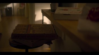 Movie still from “You” (2018), created by Sera Gamble – A pizza box sitting on top of a table; Extreme Close Up shot, High angle