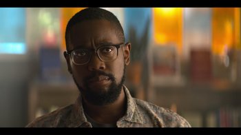 Movie still from “You” (2018), created by Sera Gamble – A person wearing glasses and a floral shirt; Close Up shot, Over the shoulder angle