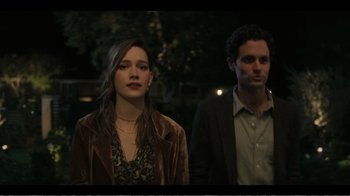 Movie still from “You” (2018), created by Sera Gamble – A man and a woman standing next to each other in the dark; Medium shot, Over the shoulder angle