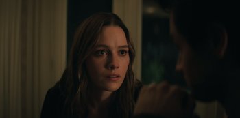 Movie still from “You” (2018), created by Sera Gamble – A young woman looking at the camera with a serious look on her face; Close Up shot, Over the shoulder angle
