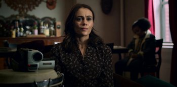 Movie still from “Archive 81” (2022), created by Rebecca Sonnenshine – A woman sitting in front of a mirror in a room; Close Up shot, Over the shoulder angle