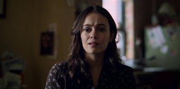 Movie still from “Archive 81” (2022), created by Rebecca Sonnenshine – A person with long dark hair; Close Up shot, Over the shoulder angle