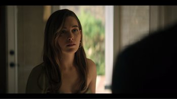 Movie still from “You” (2018), created by Sera Gamble – A young woman looking into a mirror in front of a window; Close Up shot, Over the shoulder angle