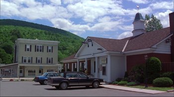 Movie still from “You Can Count on Me” (2000), directed by Kenneth Lonergan – A car parked in front of a white building; Extreme Wide shot, High angle