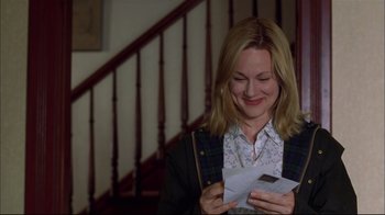 Movie still from “You Can Count on Me” (2000), directed by Kenneth Lonergan – A woman holding an envelope and looking at a piece of paper; Medium shot, Over the shoulder angle
