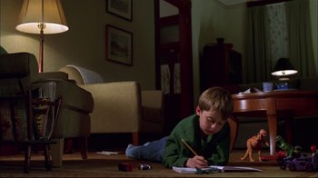 Movie still from “You Can Count on Me” (2000), directed by Kenneth Lonergan – A young boy is writing on a piece of paper; Wide shot, High angle