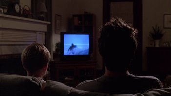 Movie still from “You Can Count on Me” (2000), directed by Kenneth Lonergan – A man and a boy watching television in a living room; Medium shot, Over the shoulder angle