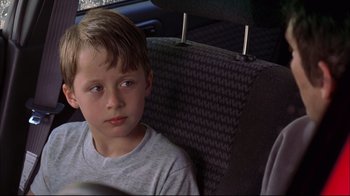 Movie still from “You Can Count on Me” (2000), directed by Kenneth Lonergan – A boy sitting in the back seat of a car; Close Up shot, Over the shoulder angle