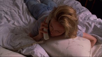 Movie still from “You Can Count on Me” (2000), directed by Kenneth Lonergan – A woman laying in a bed talking on a phone; Medium shot, High angle