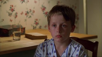 Movie still from “You Can Count on Me” (2000), directed by Kenneth Lonergan – A young boy sitting at a table in his pajamas; Close Up shot, High angle