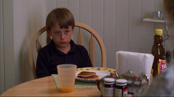 Movie still from “You Can Count on Me” (2000), directed by Kenneth Lonergan – A boy sitting at a table in front of a plate of pancakes; Medium shot, High angle