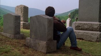 Movie still from “You Can Count on Me” (2000), directed by Kenneth Lonergan – A man sitting on top of a grave in a cemetery; Wide shot, High angle
