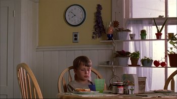 Movie still from “You Can Count on Me” (2000), directed by Kenneth Lonergan – A young boy sitting at a table with a plate of food in front of him; Medium shot, Low angle
