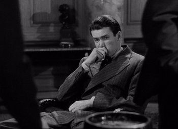 Movie still from “You Can't Take It with You” (1938), directed by Frank Capra – A black and white photo of a man sitting in a chair; Medium shot, High angle