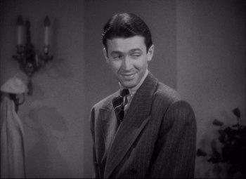 Movie still from “You Can't Take It with You” (1938), directed by Frank Capra – A man wearing a suit and tie smiling for the camera; Close Up shot, High angle
