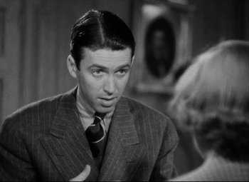 Movie still from “You Can't Take It with You” (1938), directed by Frank Capra – A man wearing a suit and tie talking to a woman; Close Up shot, Over the shoulder angle