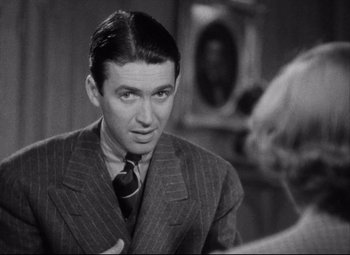 Movie still from “You Can't Take It with You” (1938), directed by Frank Capra – A man wearing a suit and tie talking to a woman; Close Up shot, Over the shoulder angle