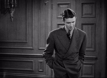 Movie still from “You Can't Take It with You” (1938), directed by Frank Capra – A black and white photo of a man in a suit; Medium shot, Over the shoulder angle