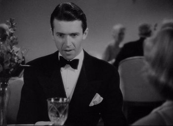 Movie still from “You Can't Take It with You” (1938), directed by Frank Capra – A man in a tuxedo holding a glass of wine; Close Up shot, Over the shoulder angle
