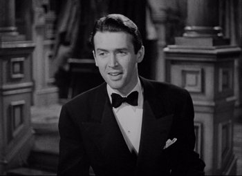 Movie still from “You Can't Take It with You” (1938), directed by Frank Capra – A man wearing a suit and a bow tie; Close Up shot, Over the shoulder angle