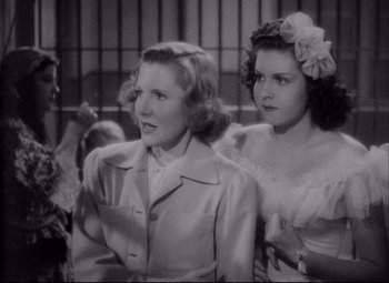 Movie still from “You Can't Take It with You” (1938), directed by Frank Capra – Two young women standing next to each other in front of a cage; Medium shot, Over the shoulder angle