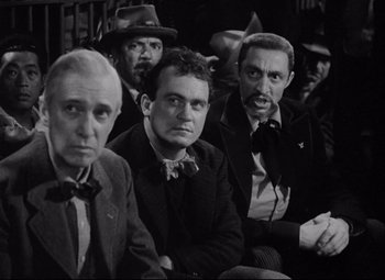 Movie still from “You Can't Take It with You” (1938), directed by Frank Capra – A black and white photo of a group of men sitting; Medium shot, Over the shoulder angle