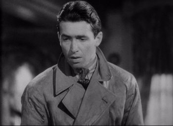 Movie still from “You Can't Take It with You” (1938), directed by Frank Capra – A black and white photo of a man in a trench coat; Close Up shot, High angle