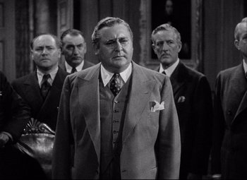Movie still from “You Can't Take It with You” (1938), directed by Frank Capra – A group of men standing next to each other in suits; Medium shot, Low angle