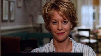 Movie still from “You've Got Mail” (1998), directed by Nora Ephron – A person sitting in front of a computer; Close Up shot, Low angle