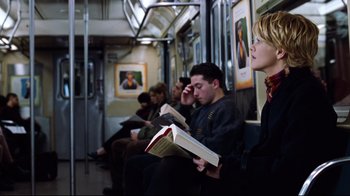 Movie still from “You've Got Mail” (1998), directed by Nora Ephron – A group of people sitting on a train reading books; Medium shot, High angle
