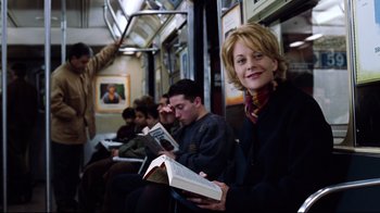 Movie still from “You've Got Mail” (1998), directed by Nora Ephron – A group of people sitting on top of a train; Medium shot, Over the shoulder angle