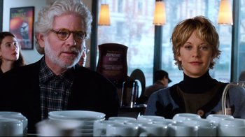 Movie still from “You've Got Mail” (1998), directed by Nora Ephron – A man and a woman sitting in front of plates; Medium shot, Over the shoulder angle