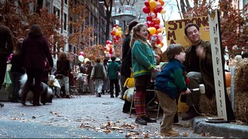 Movie still from “You've Got Mail” (1998), directed by Nora Ephron – A group of people standing on a sidewalk near balloons; Medium shot, Over the shoulder angle