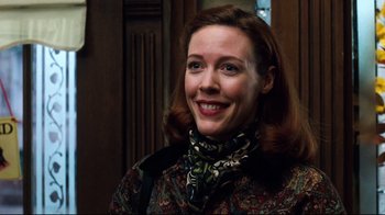 Movie still from “You've Got Mail” (1998), directed by Nora Ephron – A woman wearing a neck scarf smiling for the camera; Close Up shot, Low angle
