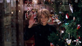Movie still from “You've Got Mail” (1998), directed by Nora Ephron – A woman waving to the camera in front of a christmas tree; Medium shot, Over the shoulder angle