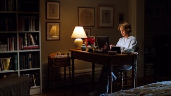 Movie still from “You've Got Mail” (1998), directed by Nora Ephron – A woman sitting at a desk using a computer; Wide shot, High angle