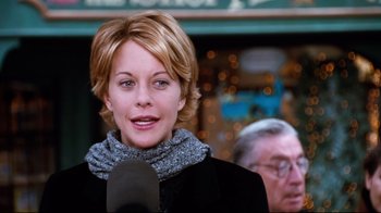 Movie still from “You've Got Mail” (1998), directed by Nora Ephron – A woman with short blonde hair wearing a black jacket and a gray scarf; Close Up shot, Low angle