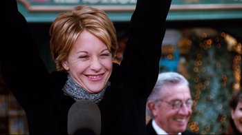 Movie still from “You've Got Mail” (1998), directed by Nora Ephron – A woman is holding up her arm in the air; Medium shot, Low angle
