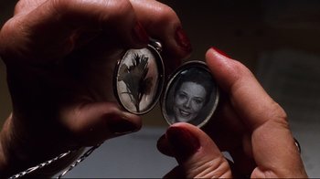 Movie still from “You've Got Mail” (1998), directed by Nora Ephron – A woman holding a picture of herself in a locket; Extreme Close Up shot, Overhead angle