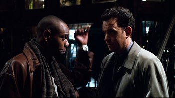 Movie still from “You've Got Mail” (1998), directed by Nora Ephron – Two men are talking to each other in a dark room; Medium shot, Over the shoulder angle