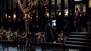 Movie still from “You've Got Mail” (1998), directed by Nora Ephron – A man sitting on top of a wooden park bench; Wide shot, Over the shoulder angle