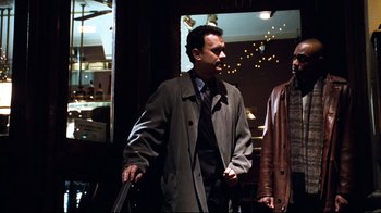 Movie still from “You've Got Mail” (1998), directed by Nora Ephron – A man in a suit and tie standing next to another man in a jacket; Medium shot, Over the shoulder angle