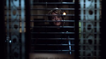 Movie still from “You've Got Mail” (1998), directed by Nora Ephron – A woman looking out a window through a metal grate; Medium shot, Over the shoulder angle