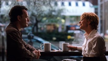 Movie still from “You've Got Mail” (1998), directed by Nora Ephron – A man and a woman sitting at a table with coffee cups; Medium shot, Over the shoulder angle